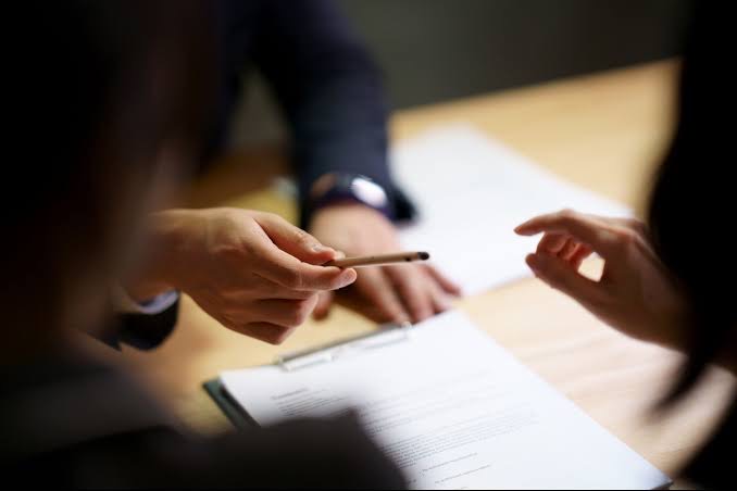 An expert assisting his client with ticking off and signing off on the necessary legal box